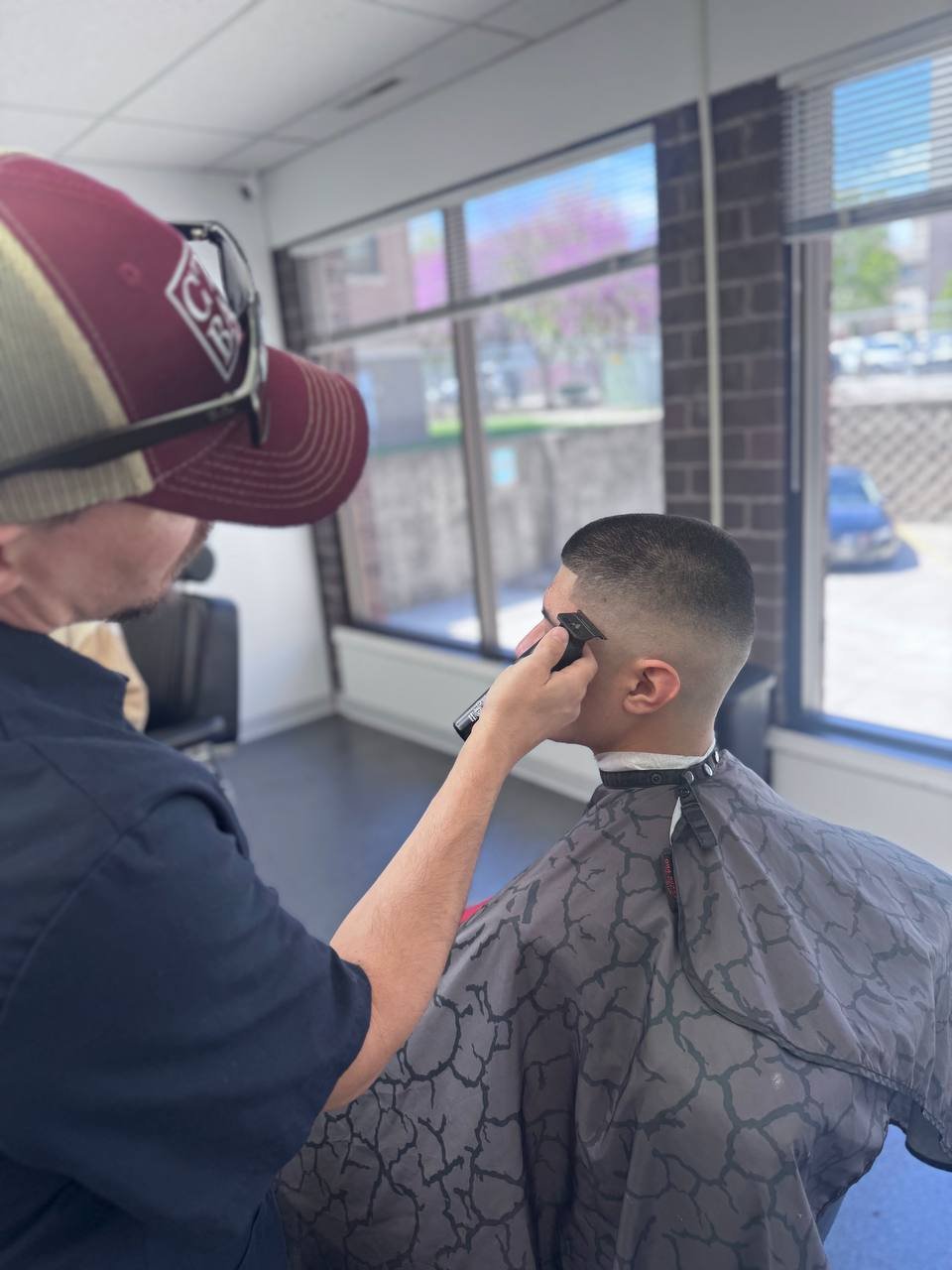Barber clipping a skin fade in the shop